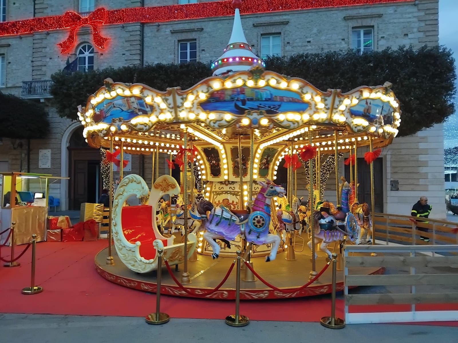 Il Carosello dei Sogni illuminato al tramonto in piazza
